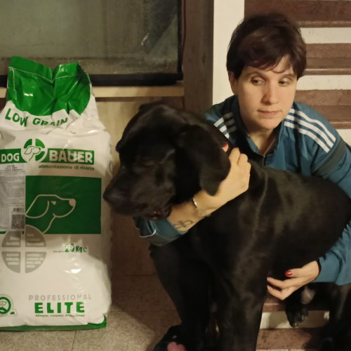 Ragazza inanellata con la sua Rottweiler e il sacco di crocchette Dogbauer