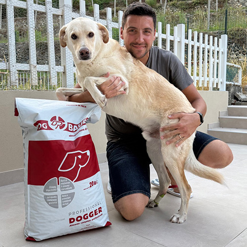 Ragazza inanellata con la sua Rottweiler e il sacco di crocchette Dogbauer